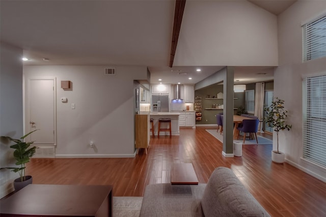 living room featuring beamed ceiling and light hardwood / wood-style floors