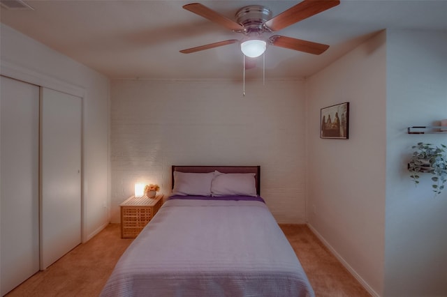 carpeted bedroom with ceiling fan and a closet