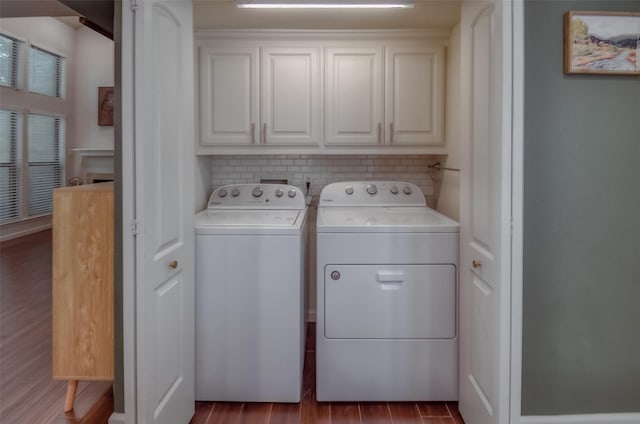 clothes washing area with dark hardwood / wood-style floors, cabinets, and separate washer and dryer