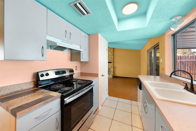 kitchen with a textured ceiling, vaulted ceiling, sink, white cabinets, and stainless steel electric range oven