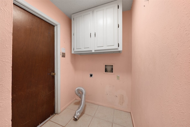 laundry area featuring electric dryer hookup, cabinets, washer hookup, light tile patterned floors, and a textured ceiling