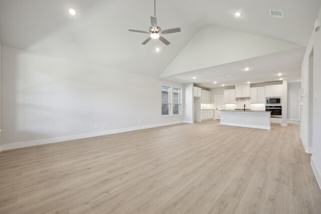 unfurnished living room with ceiling fan, light hardwood / wood-style flooring, and high vaulted ceiling