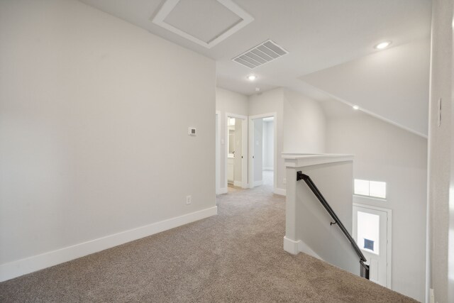 hallway with light carpet and lofted ceiling