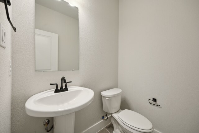 bathroom with sink, tile patterned flooring, and toilet