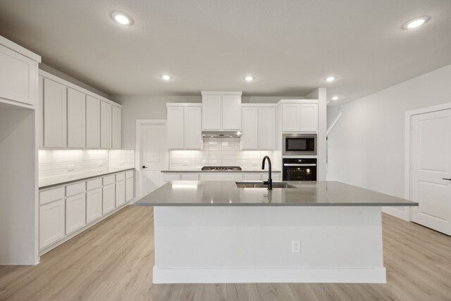 kitchen featuring a center island with sink, sink, white cabinetry, and stainless steel appliances