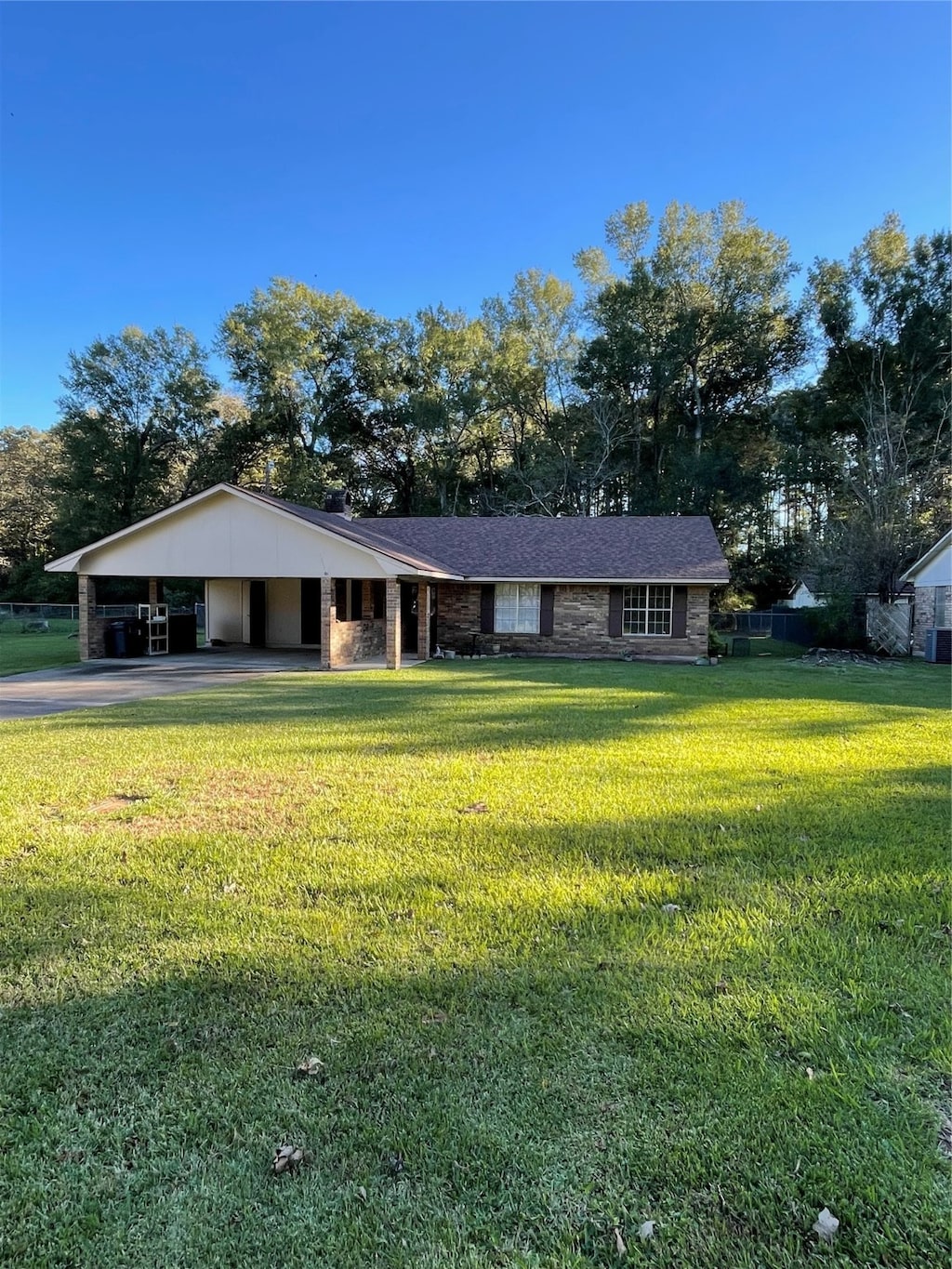 single story home featuring a carport and a front lawn