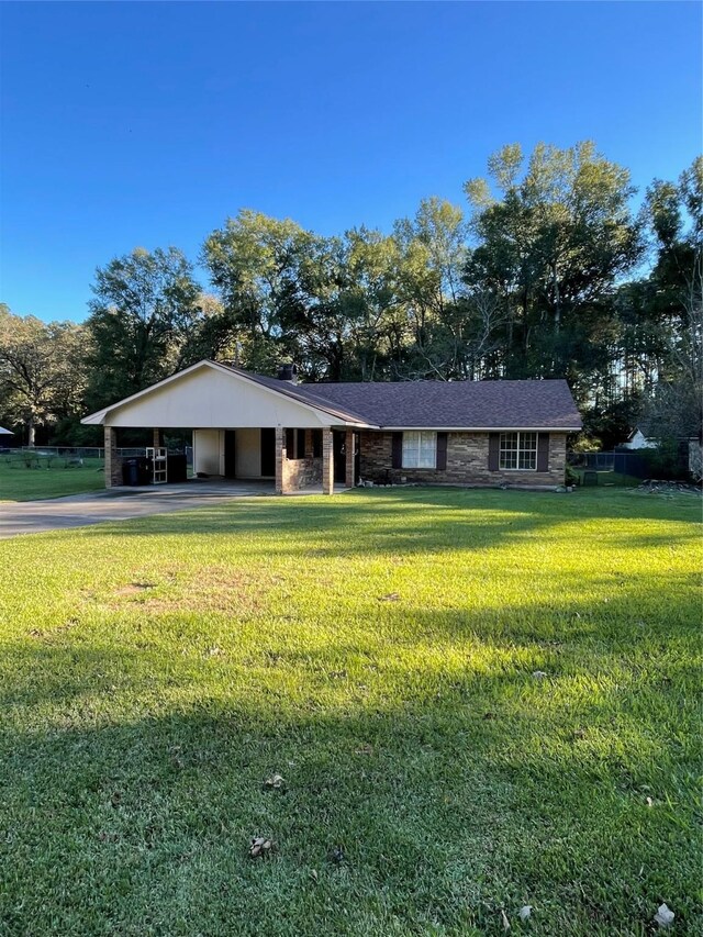 ranch-style home with a carport and a front yard