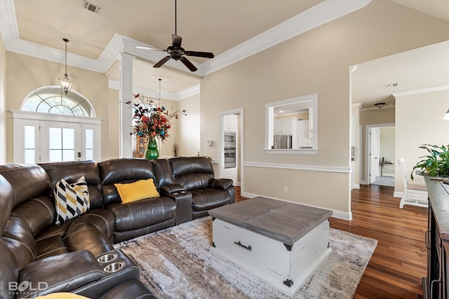 living room with ceiling fan, dark hardwood / wood-style flooring, a towering ceiling, and crown molding