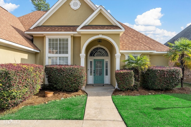 entrance to property featuring a lawn