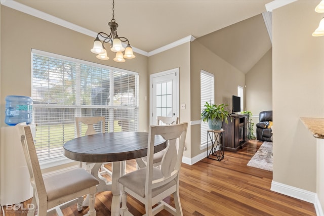 dining room with hardwood / wood-style floors, lofted ceiling, ornamental molding, and a chandelier