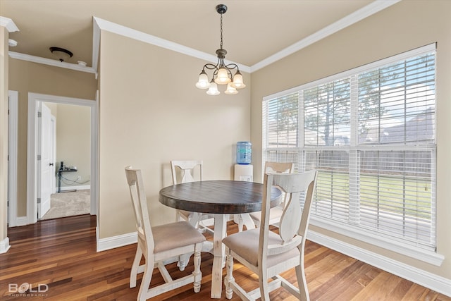 dining area with ornamental molding, a notable chandelier, and hardwood / wood-style flooring