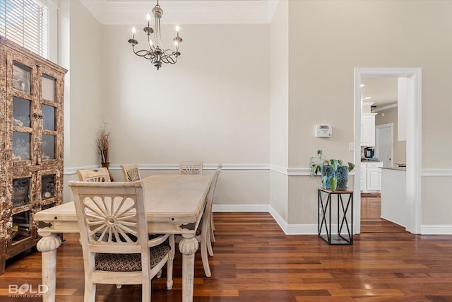 dining space featuring dark hardwood / wood-style floors, an inviting chandelier, and crown molding