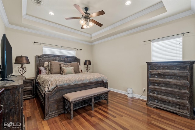 bedroom featuring a raised ceiling, ornamental molding, and dark wood-type flooring