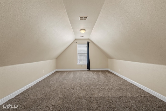 bonus room featuring carpet, a textured ceiling, and vaulted ceiling