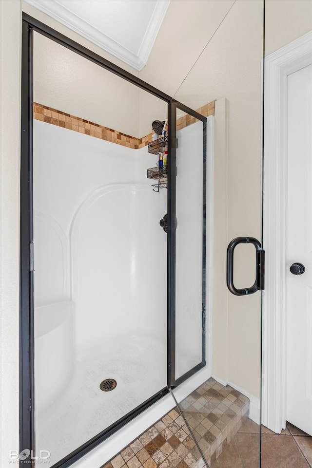 bathroom with crown molding, tile patterned flooring, and walk in shower