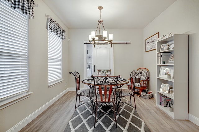 dining area featuring a notable chandelier and light wood-type flooring