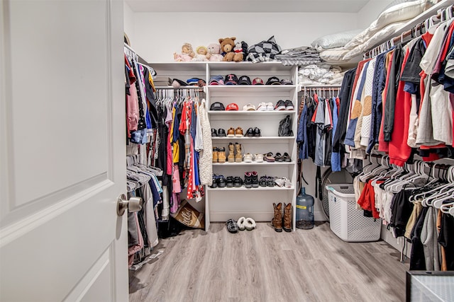 walk in closet with light hardwood / wood-style flooring