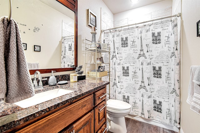 bathroom with toilet, vanity, a shower with shower curtain, and hardwood / wood-style flooring