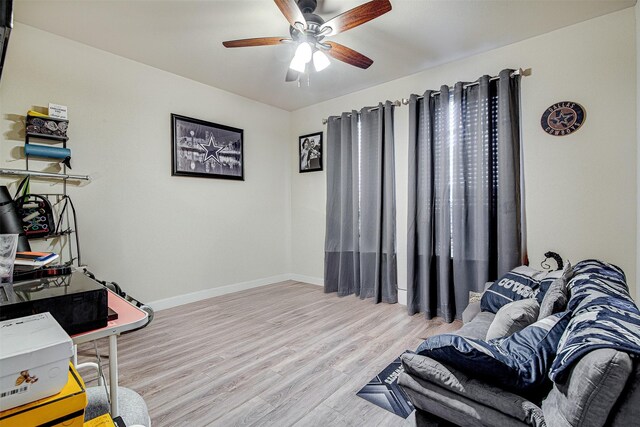 living area with ceiling fan and light hardwood / wood-style flooring