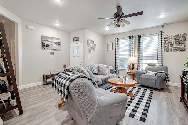 living room featuring ceiling fan and light hardwood / wood-style flooring