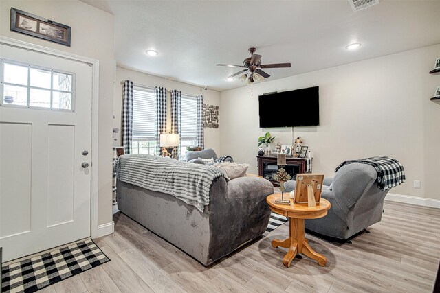 living room with ceiling fan and light hardwood / wood-style flooring