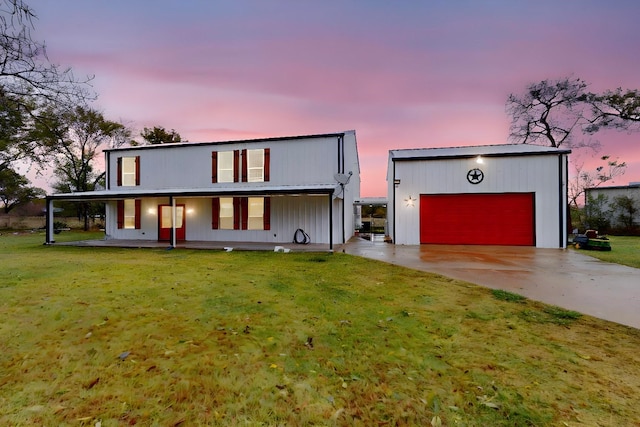 contemporary house featuring a lawn, a garage, covered porch, and an outdoor structure