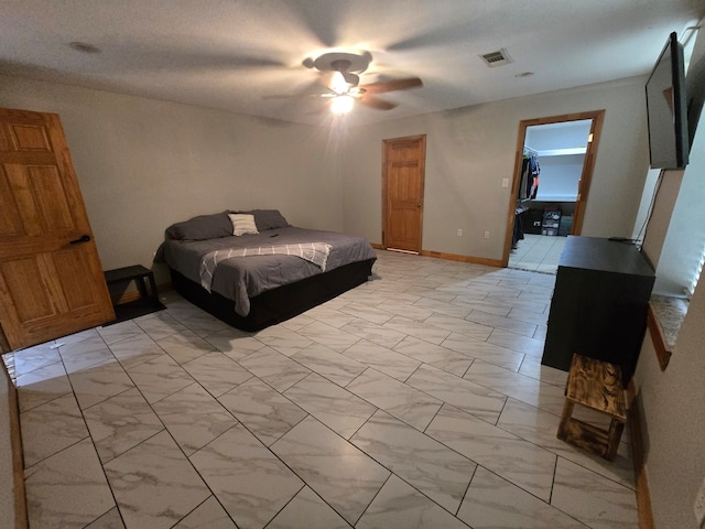 bedroom with ceiling fan, a closet, a spacious closet, and a textured ceiling