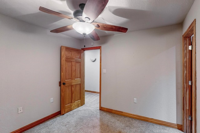 interior space featuring ceiling fan, light colored carpet, and a textured ceiling