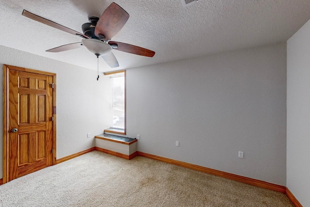 spare room with ceiling fan, carpet, and a textured ceiling