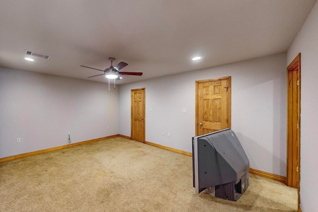 spare room featuring light carpet and ceiling fan