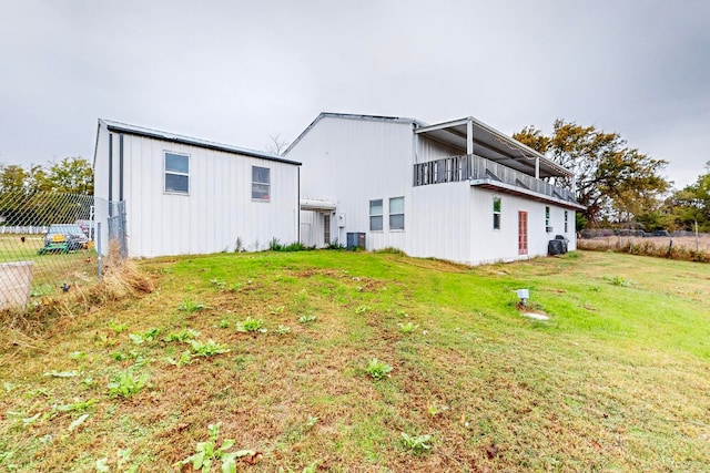 rear view of house featuring a yard and cooling unit