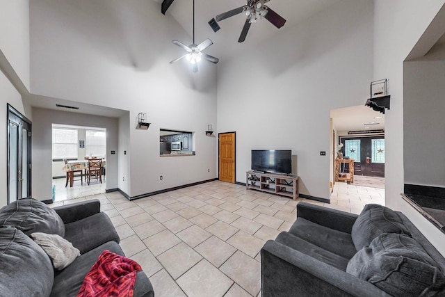 living room with ceiling fan, beam ceiling, and high vaulted ceiling