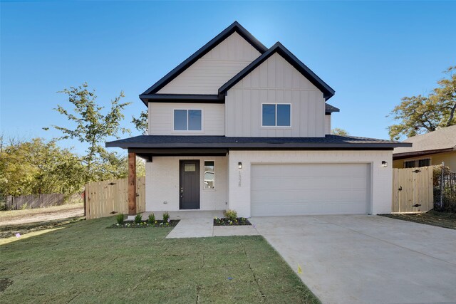 view of front of property featuring covered porch, a garage, and a front lawn