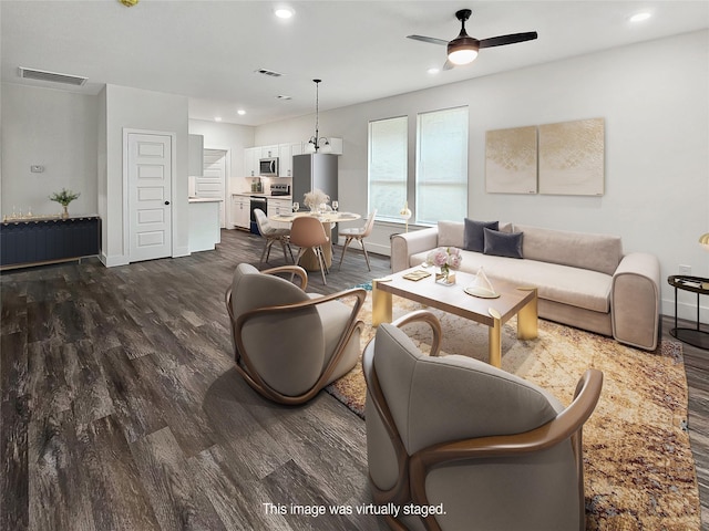 living room featuring ceiling fan and dark hardwood / wood-style floors