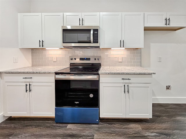 kitchen featuring white cabinets, stainless steel appliances, light stone counters, and dark hardwood / wood-style floors