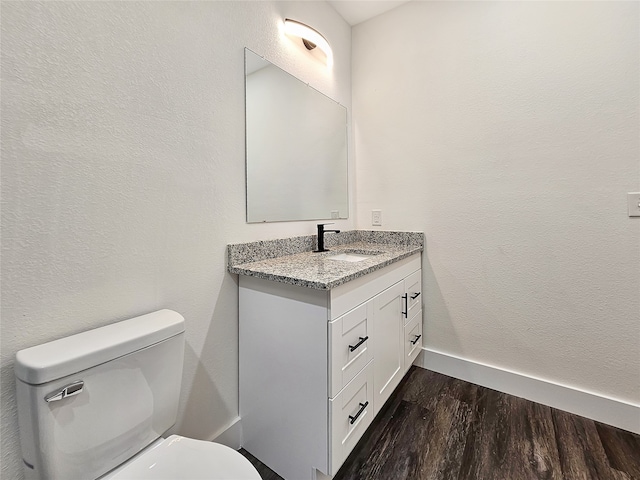 bathroom featuring wood-type flooring, vanity, and toilet