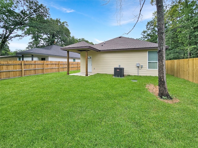 back of house with central AC and a lawn