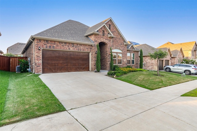 view of front facade featuring brick siding, a shingled roof, concrete driveway, a front yard, and an attached garage