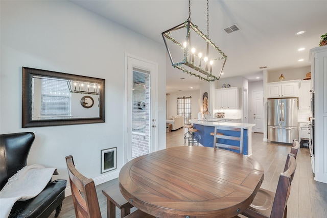 dining area with light wood-style flooring, recessed lighting, visible vents, and baseboards