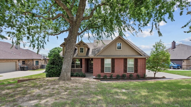 view of front of property featuring a front yard, central AC, and covered porch