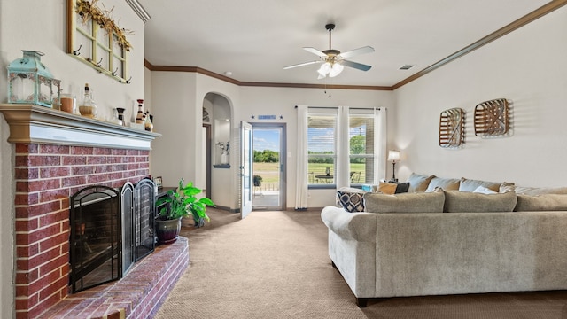 carpeted living room featuring ceiling fan, crown molding, and a brick fireplace