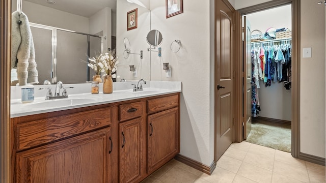 bathroom with tile patterned flooring, vanity, and a shower with shower door