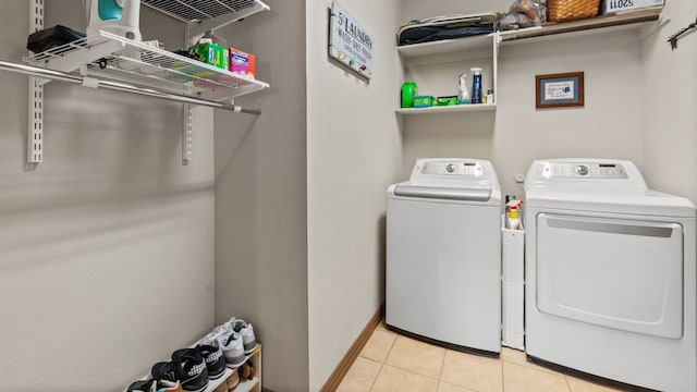 clothes washing area featuring independent washer and dryer and light tile patterned flooring