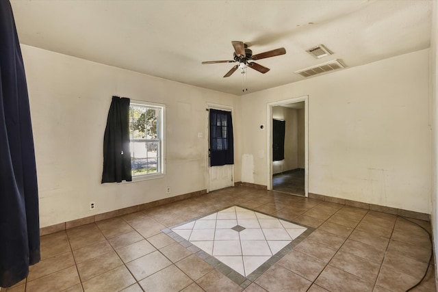 tiled spare room featuring ceiling fan