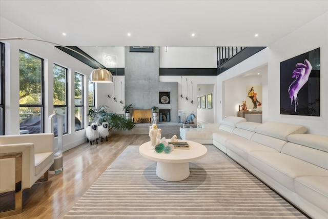 living room with wood-type flooring and a large fireplace