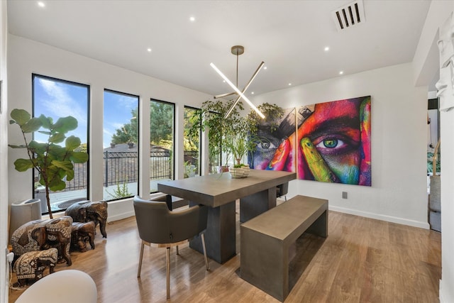 dining area featuring light hardwood / wood-style flooring and a notable chandelier