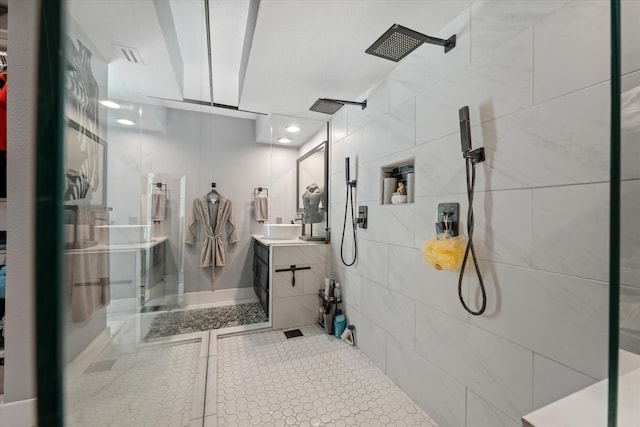 bathroom featuring a tile shower, vanity, and tile walls