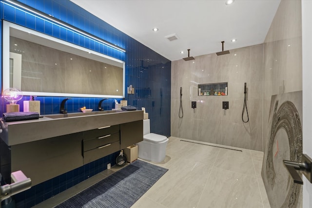 bathroom with a shower, vanity, toilet, and tile walls