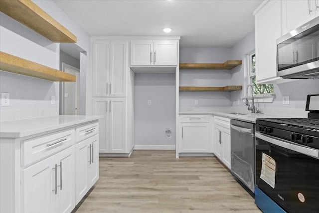 kitchen with white cabinetry, sink, light hardwood / wood-style flooring, and stainless steel appliances