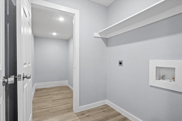 clothes washing area with hookup for a washing machine, electric dryer hookup, and light hardwood / wood-style floors